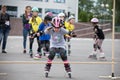 Competitions in roller sport. A girl on roller skates jumps over a stick