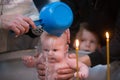 The priest performs the rite of baptism of the child.