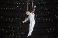 Aerial acrobat performs a circus trick.