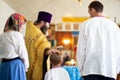 Orthodox rite of baptism in the Slavic church. The priest reads a prayer to the boy and his godparents in the church Royalty Free Stock Photo