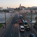 Belarus, Grodno July 15, 2022: The movement of cars and public transport on the bridge over the river. Thick morning fog over the