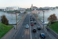 Belarus, Grodno July 15, 2022: The movement of cars and public transport on the bridge over the river. Thick morning fog over the