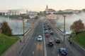 Belarus, Grodno July 15, 2022: The movement of cars and public transport on the bridge over the river. Thick morning fog over the