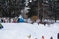 Parents and children ride from the snow slides in winter have fun resting in nature. Royalty Free Stock Photo