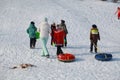 Parents and children ride from the snow slides in winter have fun resting in nature. Royalty Free Stock Photo