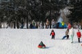 Parents and children ride from the snow slides in winter have fun resting in nature. Royalty Free Stock Photo