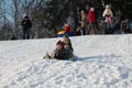 Parents and children ride from the snow slides in winter have fun resting in nature. Royalty Free Stock Photo