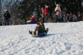 Parents and children ride from the snow slides in winter have fun resting in nature. Royalty Free Stock Photo