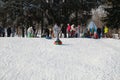 Parents and children ride from the snow slides in winter have fun resting in nature. Royalty Free Stock Photo