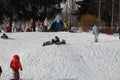 Parents and children ride from the snow slides in winter have fun resting in nature. Royalty Free Stock Photo