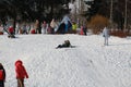 Parents and children ride from the snow slides in winter have fun resting in nature. Royalty Free Stock Photo