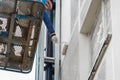 Belarus, Minsk - May 28, 2020: A worker on a lifting platform paints the facade of a new modern urban building under construction Royalty Free Stock Photo