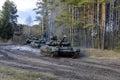 Russian armored combat vehicles are navigating through marshland through forests.