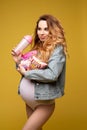 11 27 2019 Belarus Minsk: Smiling beautiful pregnant woman holding chips and looking to the side