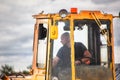 The driver in the cockpit of the bulldozer.