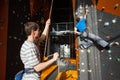 Belayer insuring the climber on rock wall indoors