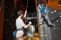 Belayer insuring the climber on rock wall indoors