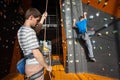 Belayer insuring the climber on rock wall indoors