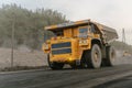 A BelAZ dump truck loaded with ore drives through an open pit mine.