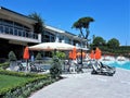 Hotel resort scene with children pool, lounge chairs and pine trees Royalty Free Stock Photo