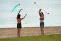 Two women juggling on the beach