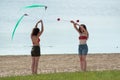 Two women juggling on the beach