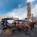 Belfort tower in Bruges at the Market Square with horses, Belgium. Royalty Free Stock Photo