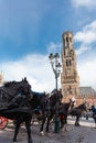 Belfort tower in Bruges at the Market Square with horses, Belgium. Royalty Free Stock Photo