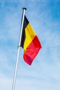 Belgian flag on a pole against blue sky Royalty Free Stock Photo