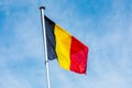 Belgian flag on a pole against blue sky Royalty Free Stock Photo