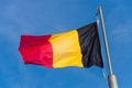 Belgian flag waving against blue sky Royalty Free Stock Photo