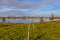 Belgian nature reserve De Wissen Maasvallei, fence of wooden posts and wire on floodplain on bank of river