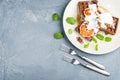 Belgian soft waffles with blood orange, cream, marple syrup and mint on white plates Royalty Free Stock Photo