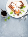 Belgian soft waffles with blood orange, cream, marple syrup and mint on white plates Royalty Free Stock Photo