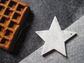 Belgian waffle and white wooden star on a granite black and white background