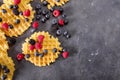 Belgian waffles with berries on the gray background. Sweet food concept.