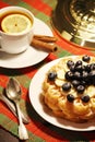 Belgian waffles with blueberry and a cup of tea with lemon Royalty Free Stock Photo