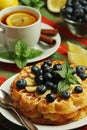 Belgian waffles with blueberry and a cup of tea with lemon Royalty Free Stock Photo