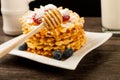 Belgian waffles with raspberries and sieving sugar powder and honey served with jug of milk on a white table Royalty Free Stock Photo