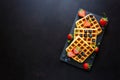 Belgian waffles with strawberries and blueberries on slate plate on dark wooden background. Top view. Copy space Royalty Free Stock Photo