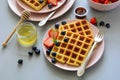 Belgian waffles with strawberries and honey on gray background. Healthy breakfast concept Royalty Free Stock Photo