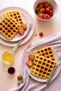 Belgian waffles with strawberries and honey on pink background. Healthy breakfast concept Royalty Free Stock Photo