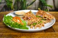 Belgian waffles on white plate with greens on wooden table