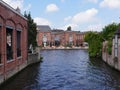 Brick buildings partly with climbing plants overgrown on the bank