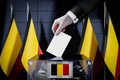 Belgium flags, hand dropping ballot card into a box - voting, election concept