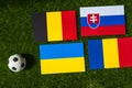 Belgium Leads Group E: Flags of Belgium, Slovakia, Romania, Ukraine, and soccer ball on green grass at Europe football tournament Royalty Free Stock Photo