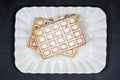 Belgium waffers with sugar powder on ceramic plateon black board background