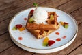 Belgium waffles with fruits and ice cream. Served with plate on wooden table. Royalty Free Stock Photo