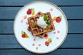 Belgium waffles with fruits and ice cream. Served with plate on wooden table. Royalty Free Stock Photo