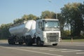 Belgorod , Russia - JUN, 22, 2020: Flour Volvo truck with a round barrel semi trailer moving ocountry road. Side view